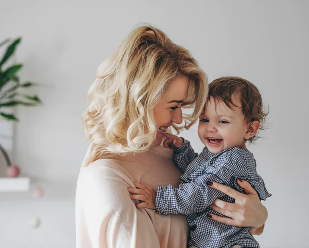 A mother smiling at her happy child, representing the 'Baby & Kids' category.