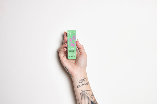 Hand holding a bottle of QLife Q Detox natural herbal drops